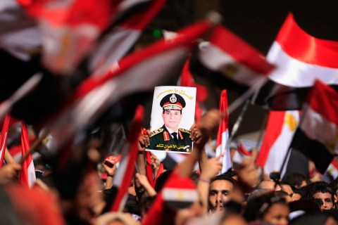 Protesters, who are against Egyptian President Mohamed Mursi, hold a poster featuring the head of Egypt's armed forces General Abdel Fattah al-Sisi, in Tahrir Square in Cairo